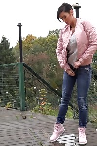 Black Haired Doll Squats To Piss On Decking